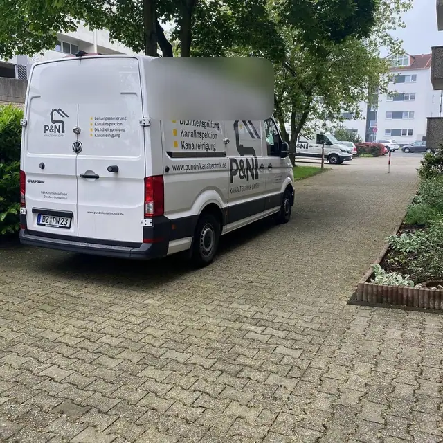 Transporter des Partnerbetriebs P&N Kanaltechnik bei einem Einsatz in einer Wohnanlage